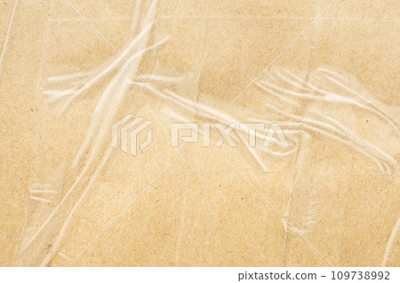 transparent adhesive tape on old brown cardboard paper background 109738992