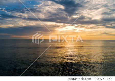In morning sun rises over water waves of ocean In morning sun rises over water waves of ocean 109739768