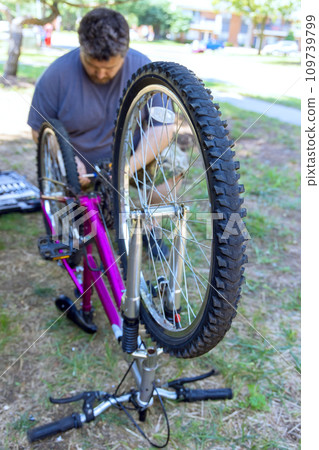 Fixing his bike chain after it broke with repair services 109739799