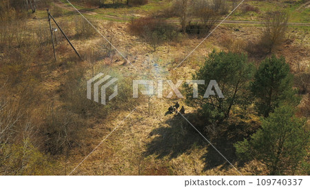 Men Dressed As US American Soldiers Of USA Infantry Of World War II open fire shooting mortar In spring Autumn Day. Soldiers shots mortar during battle In dry grass. Aerial view elevated shot 109740337