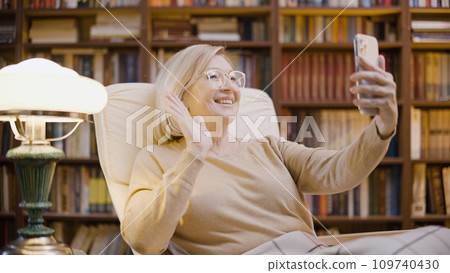 Woman in her 50s making a video call on her smartphone, communication with relatives 109740430