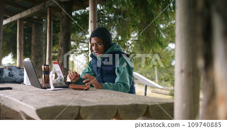 Tourist remotely studies during holidays in mountain forest 109740885