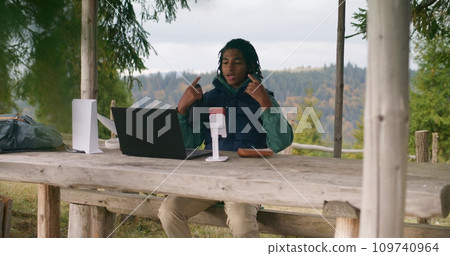 Teenager remotely studies during holidays in mountain forest Teenager remotely studies during holidays in mountain forest 109740964
