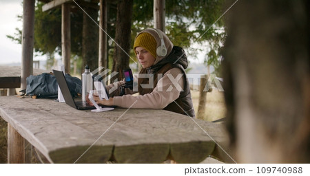 Young streamer sits in gazebo and talks into microphone Young streamer sits in gazebo and talks into microphone 109740988