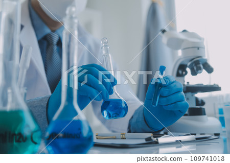biochemical research scientist team working with microscope for coronavirus vaccine development in pharmaceutical research labolatory, selective focus 109741018