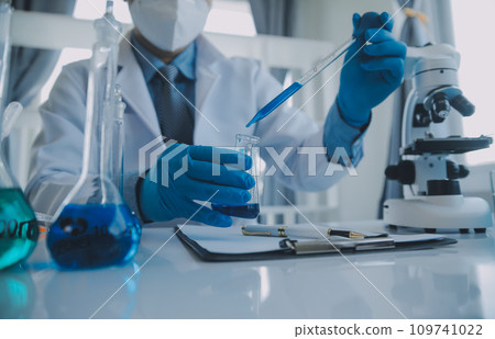 biochemical research scientist team working with microscope for coronavirus vaccine development in pharmaceutical research labolatory, selective focus 109741022