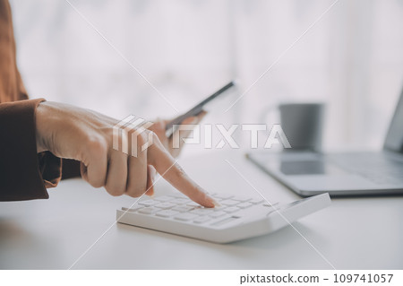 Portrait of Young Asian woman hand freelancer is working her job on computer tablet in modern office. Doing accounting analysis report real estate investment data, Financial and tax systems concept. Portrait of Young Asian woman hand freelancer is working her job on computer tablet in modern office. Doing accounting analysis report real estate investment data, Financial and tax systems concept. 109741057