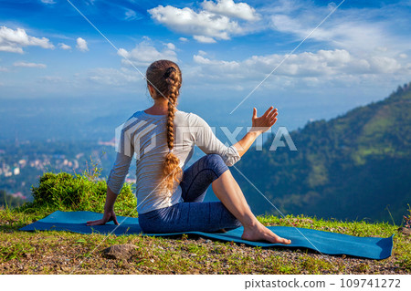 Woman practices yoga asana outdoors 109741272