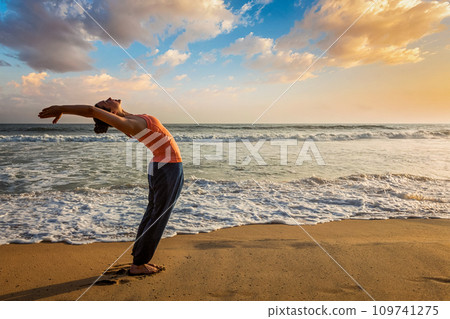 Woman doing yoga Sun salutation Surya Namaskar Woman doing yoga Sun salutation Surya Namaskar 109741275
