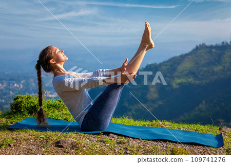 Woman doing Ashtanga Vinyasa Yoga asana Navasana - boat pose 109741276