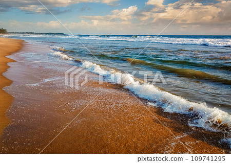 Wave surging on sand Wave surging on sand 109741295