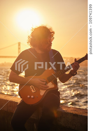 Street musician playing electric guitar in the street 109741399