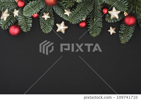 Christmas black background with fir tree, baubles and stars. Top view with copy space for your text 109741710