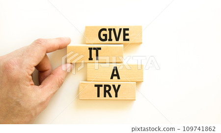 Give it a try symbol. Concept word Give it a try on beautiful wooden block. Beautiful white table white background. Businessman hand. Business give it a try concept. Copy space. 109741862