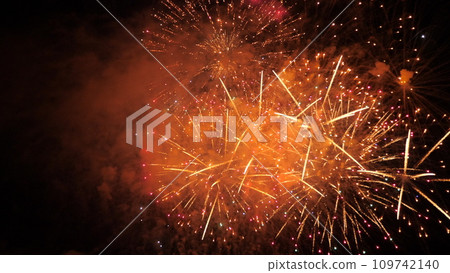 Fantastic fireworks show with sparkling blasts and smoke in black night sky. Fireworks dazzling display explode for party visitors at night. Abstract flash patterns at fireworks festival in dark sky Fantastic fireworks show with sparkling blasts and smoke in black night sky. Fireworks dazzling display explode for party visitors at night. Abstract flash patterns at fireworks festival in dark sky 109742140