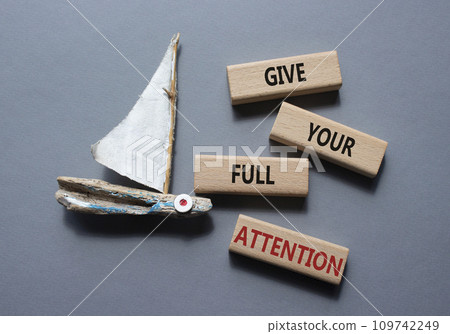 Give your full Attention symbol. Concept word Give your full Attention on wooden blocks. Beautiful grey background with boat. Business and Give your full Attention concept. Copy space 109742249