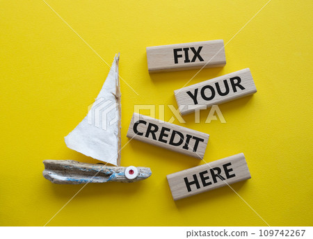 Fix your credit here symbol. Concept words Fix your credit here on wooden blocks. Beautiful yellow background with boat. Business and Fix your credit here concept. Copy space. 109742267
