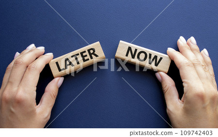 Now vs Later symbol. Concept word Now vs Later on wooden blocks. Businessman hand. Beautiful deep blue background. Business and Now vs Later concept. Copy space 109742403