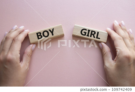 Boy or Girl symbol. Concept word Boy or Girl on wooden blocks. Man hand. Beautiful pink background. Gender and Boy or Girl concept. Copy space 109742409