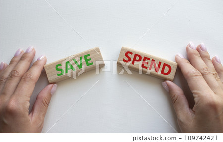 Save or Spend symbol. Concept word Save or Spend on wooden blocks. Businessman hand. Beautiful white background. Business and Save or Spend concept. Copy space Save or Spend symbol. Concept word Save or Spend on wooden blocks. Businessman hand. Beautiful white background. Business and Save or Spend concept. Copy space 109742421