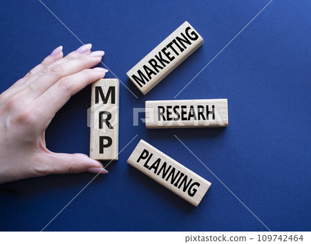 MRP - Marketing Research Planning symbol. Concept word MRP on wooden cubes. Businessman hand. Beautiful deep blue background. Business and MRP concept. Copy space. MRP - Marketing Research Planning symbol. Concept word MRP on wooden cubes. Businessman hand. Beautiful deep blue background. Business and MRP concept. Copy space. 109742464