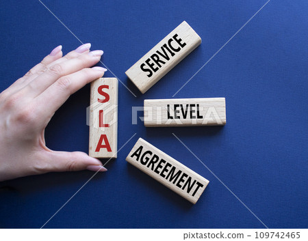 SLA - Service Level Agreement. Wooden blocks with word SLA. Businessman hand. Beautiful deep blue background. Business and Service Level Agreement concept. Copy space. SLA - Service Level Agreement. Wooden blocks with word SLA. Businessman hand. Beautiful deep blue background. Business and Service Level Agreement concept. Copy space. 109742465