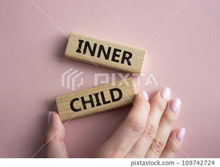 Inner Child symbol. Wooden blocks with words Inner Child. Beautiful pink background. Businessman hand. Business and Inner Child concept. Copy space. 109742724