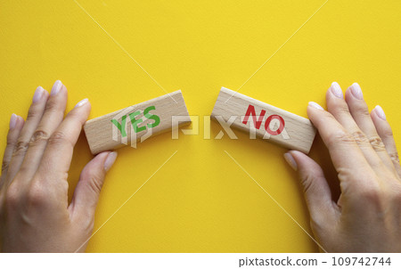 Yes or No symbol. Concept word Yes or No on wooden blocks. Businessman hand. Beautiful yellow background. Business and Yes or No concept. Copy space 109742744