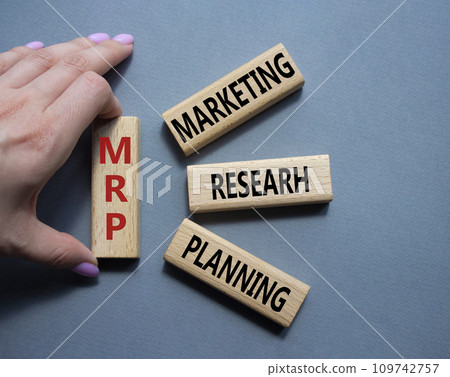 MRP - Marketing Research Planning symbol. Concept word MRP on wooden cubes. Businessman hand. Beautiful grey background. Business and MRP concept. Copy space. MRP - Marketing Research Planning symbol. Concept word MRP on wooden cubes. Businessman hand. Beautiful grey background. Business and MRP concept. Copy space. 109742757