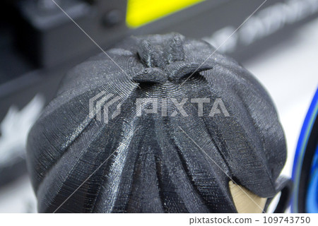Prototype of head with black hair 3D printed from melted plastic. Close-up model of toy created on 3D printer. New innovation modern 3D printing technologies. Additive progressive technology. 3D model 109743750