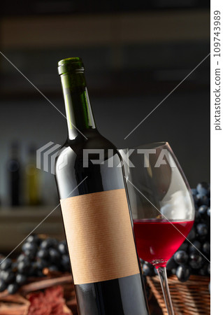 Bottle and glass of red wine with blue grapes. Bottle and glass of red wine with blue grapes. 109743989