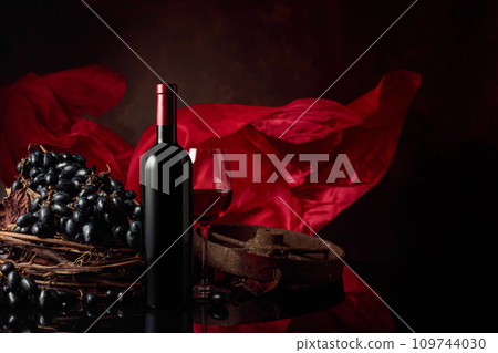 Red wine with grapes on a background of red flutters curtain. Red wine with grapes on a background of red flutters curtain. 109744030