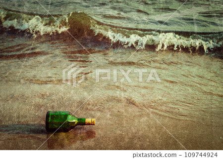 Message bottle on beach in waves Message bottle on beach in waves 109744924