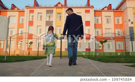 kid child holds father hand, daddy little schoolgirl going class backpack, family. happy family, father leads girl daughter by hand school, happy family concept, child goes class school building learn 109745884
