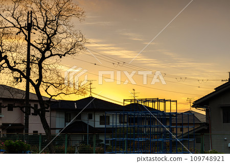 雨停的傍晚,夕陽鋪滿了西邊的天空,住宅區屋頂後面的夕陽和金色的天空。 雨停的傍晚,夕陽鋪滿了西邊的天空,住宅區屋頂後面的夕陽和金色的天空。 109748921