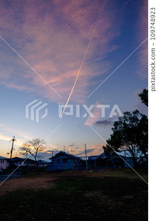 The sunset spread across the western sky in the evening after the rain stopped. Madder clouds and contrails spread across the sky① 109748923