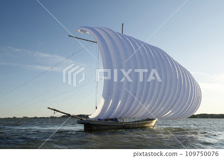 A sailing boat with full white sails floats on the calm surface of Lake Kasumigaura under clear skies. 109750076