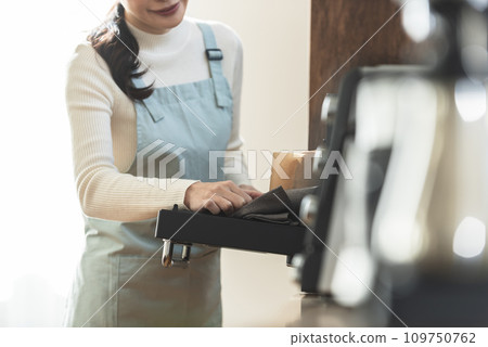 圍裙的女人從烤箱拿出蛋糕 109750762