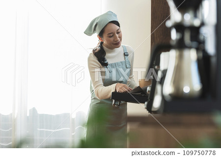 圍裙的女人從烤箱拿出蛋糕 109750778