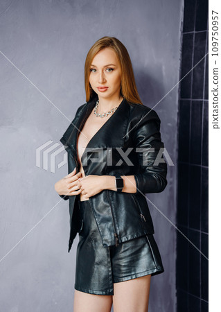 Beautiful young red-haired long-haired woman in black leather shirt Beautiful young red-haired long-haired woman in black leather shirt 109750957