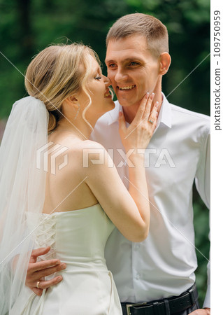 Gentle and happy newlyweds on a walk in the park. Gentle and happy newlyweds on a walk in the park. 109750959