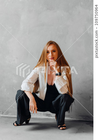 sexy redhead young woman in white shirt sitting on the floor sexy redhead young woman in white shirt sitting on the floor 109750964