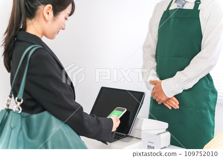 A woman uses electronic money on her smartphone to make electronic payments, mobile payments, cashless payments, and touchless payments. A woman uses electronic money on her smartphone to make electronic payments, mobile payments, cashless payments, and touchless payments. 109752010