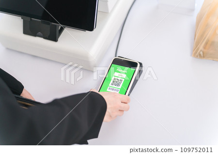 A woman uses electronic money on her smartphone to make electronic payments, mobile payments, cashless payments, and touchless payments. 109752011