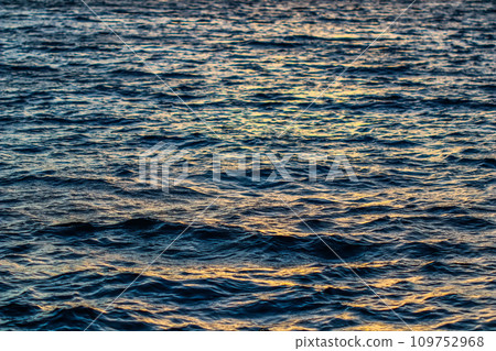Blurred texture background for design. Golden bokeh of sea waves at sunset. Summer vacation and coastal nature concept Blurred texture background for design. Golden bokeh of sea waves at sunset. Summer vacation and coastal nature concept 109752968