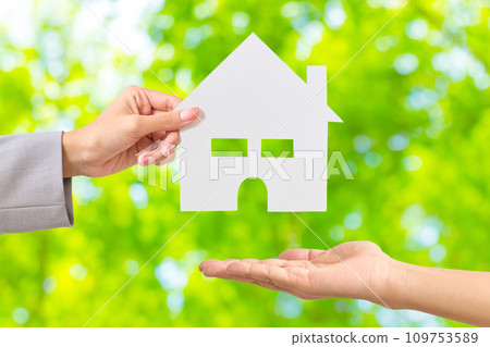 一個女人的手遞過一張房子形狀的白紙 109753589