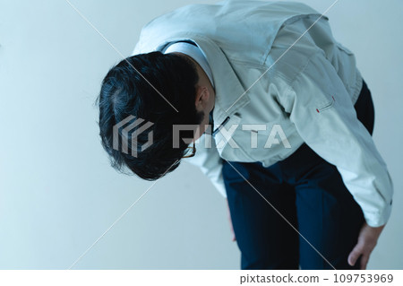 A man in work clothes apologizing 109753969