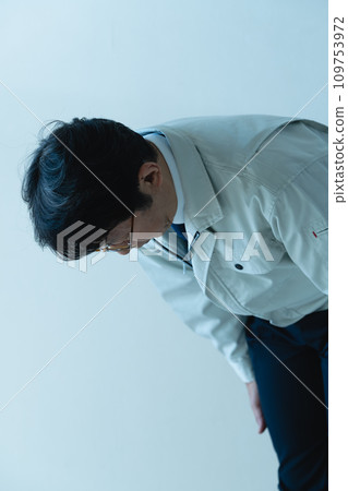 A man in work clothes apologizing A man in work clothes apologizing 109753972