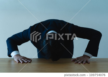 A man in a suit apologizing A man in a suit apologizing 109754076
