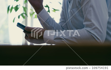 A middle-aged man gets shocked when he looks at his smartphone 109754191